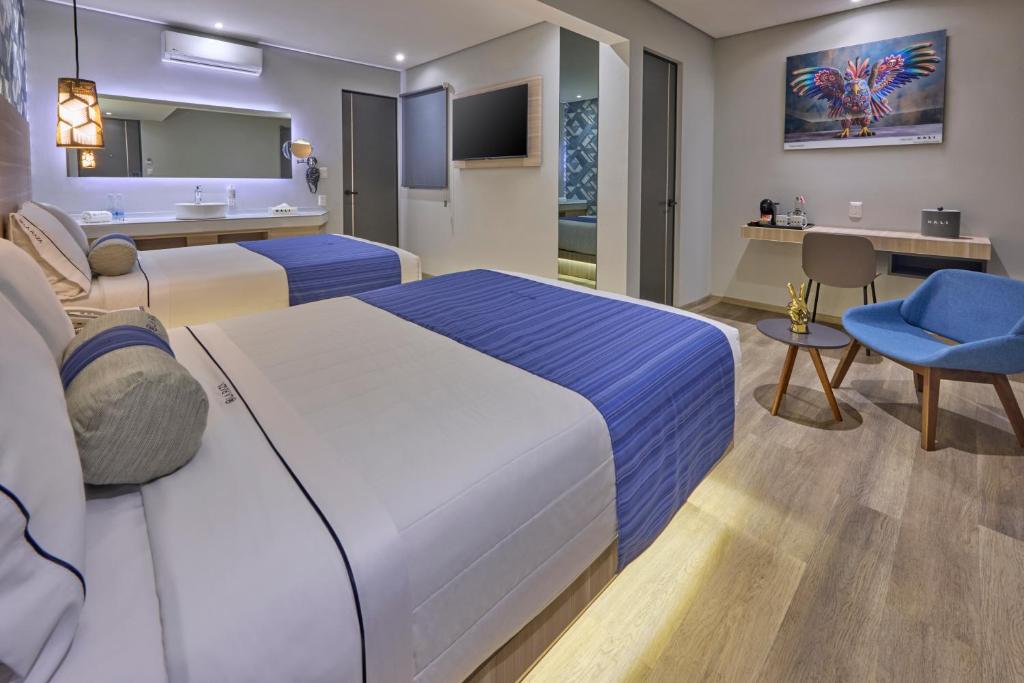 A two-bed room with a compact desk, chair, television, and vanity area.