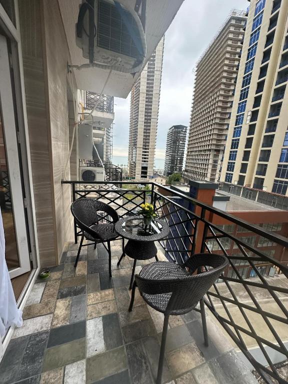 a balcony with chairs and a table on a building at Apartnuca in Batumi