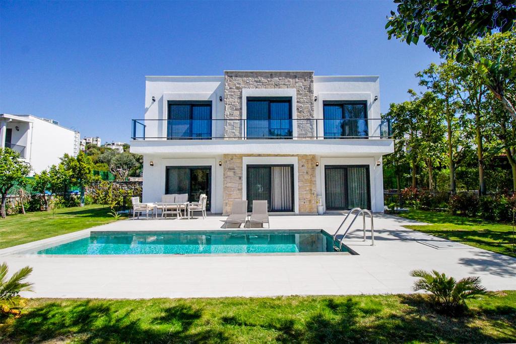 a villa with a swimming pool in front of a house at Villa Casa LUZ in Bodrum City