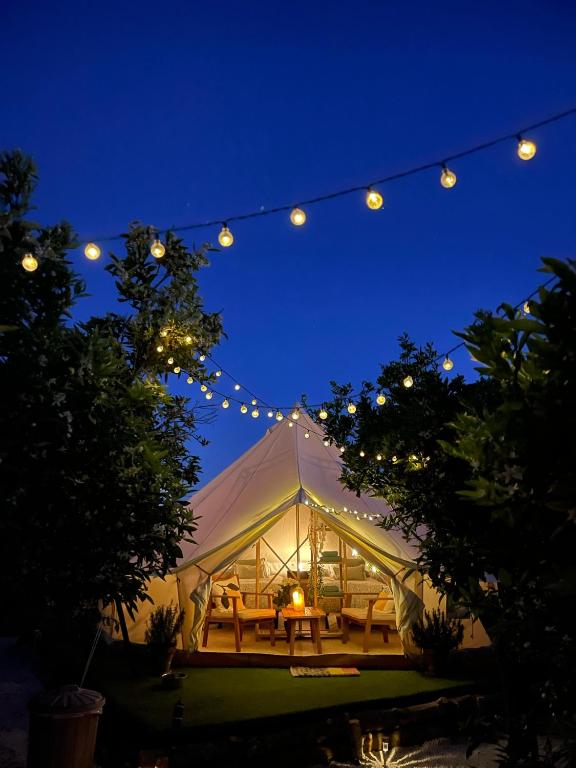 a tent with a table and lights at night at Glamping de Huerta La Arboleja in Murcia