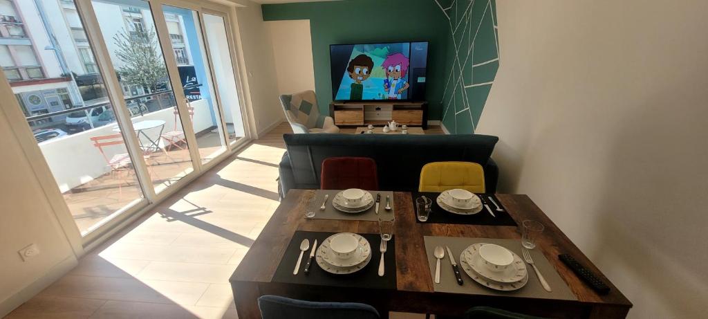 ein Wohnzimmer mit Tisch und Fernseher in der Unterkunft Appartement Hyper-Centre 3 Chambres 3 Salles de Bain Parking in Saint-Nazaire
