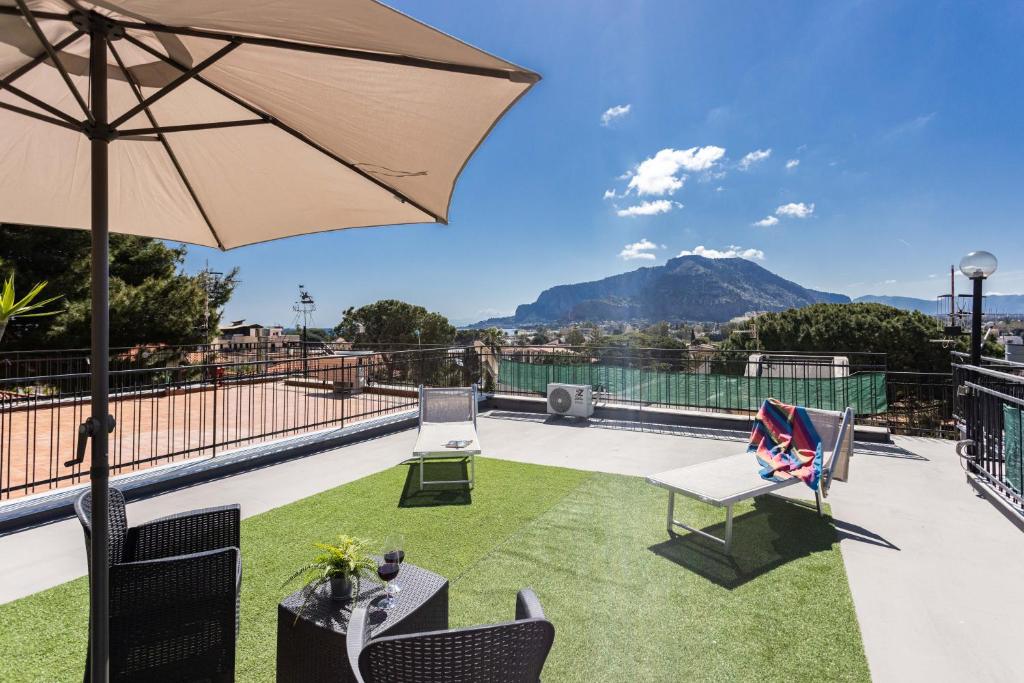a patio with an umbrella and a table and chairs at Mondello House Eraclea in Mondello