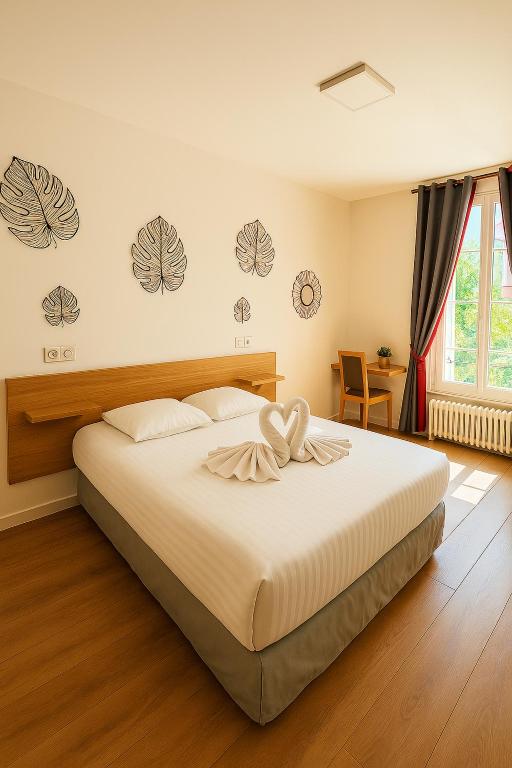 une chambre avec un grand lit dans une pièce dans l'établissement Logis Hôtel du Cirque Troyes centre historique, à Troyes