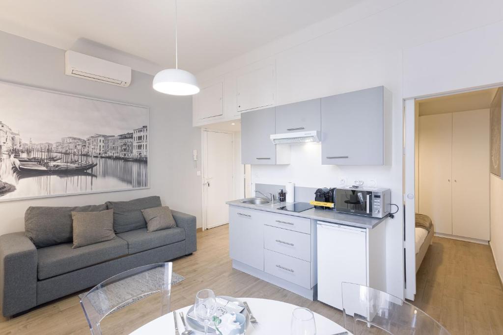 un salon avec un canapé et une cuisine dans l'établissement Les Serbes - 6mn du Palais&Plage, centre, charmant, à Cannes