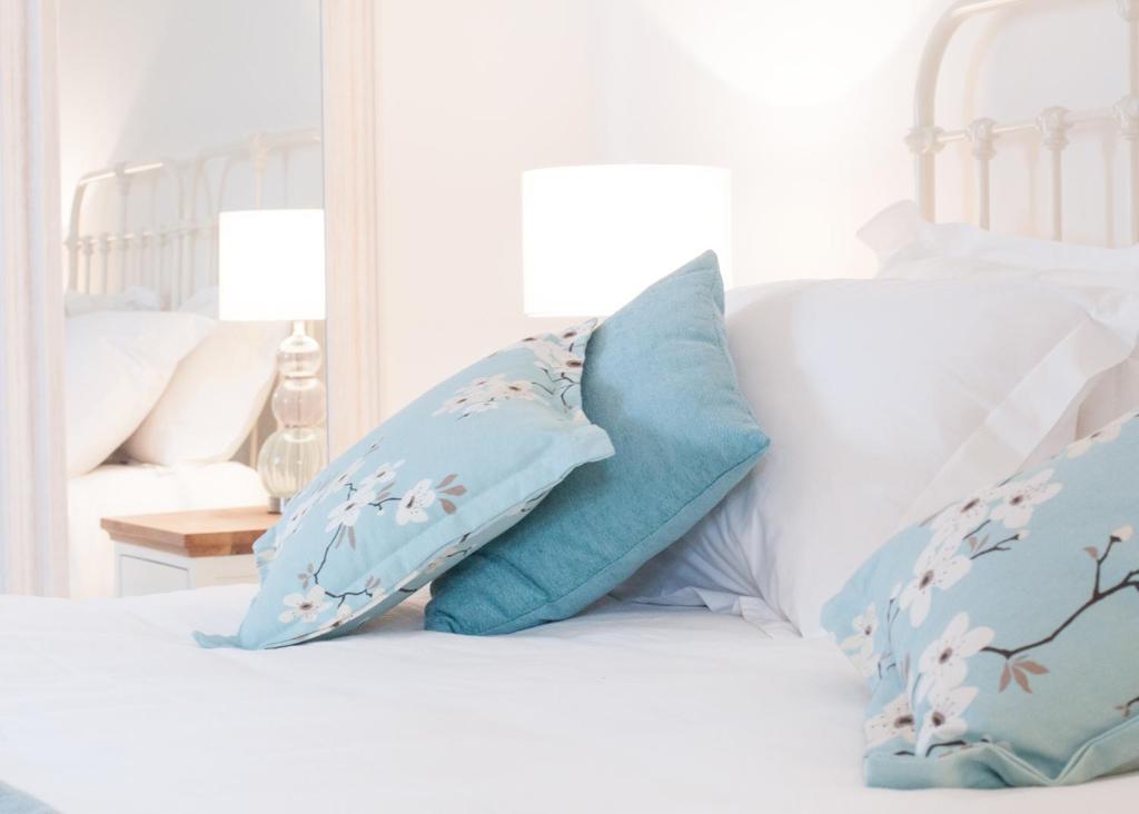 Una cama con dos almohadas azules. en Padstow Bed & Breakfast, en Padstow