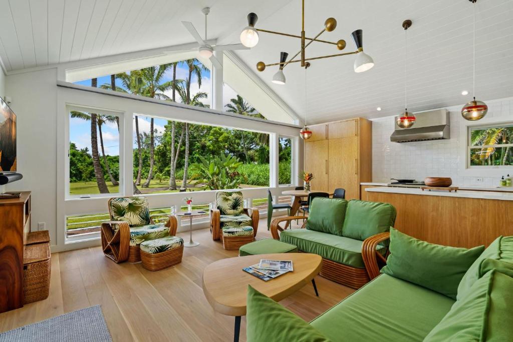 a living room with green furniture and a kitchen at Coconut Hut in Kilauea