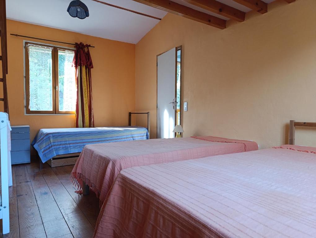 une chambre avec deux lits et une fenêtre dans l'établissement Gite des Suvieres, à Les Mayons