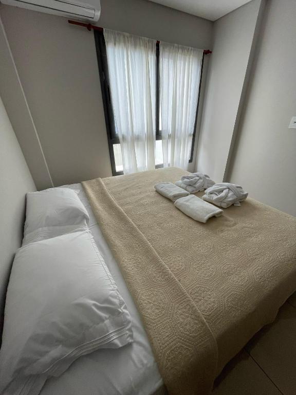 una camera da letto con un letto con lenzuola bianche e una finestra di Dpto totalmente equipado a Corrientes