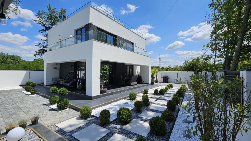una casa bianca con un giardino di fronte di Vila LakeView Snagov, Terasă pe Acoperiș, Self Check-in, Parcare Privată a Snagov