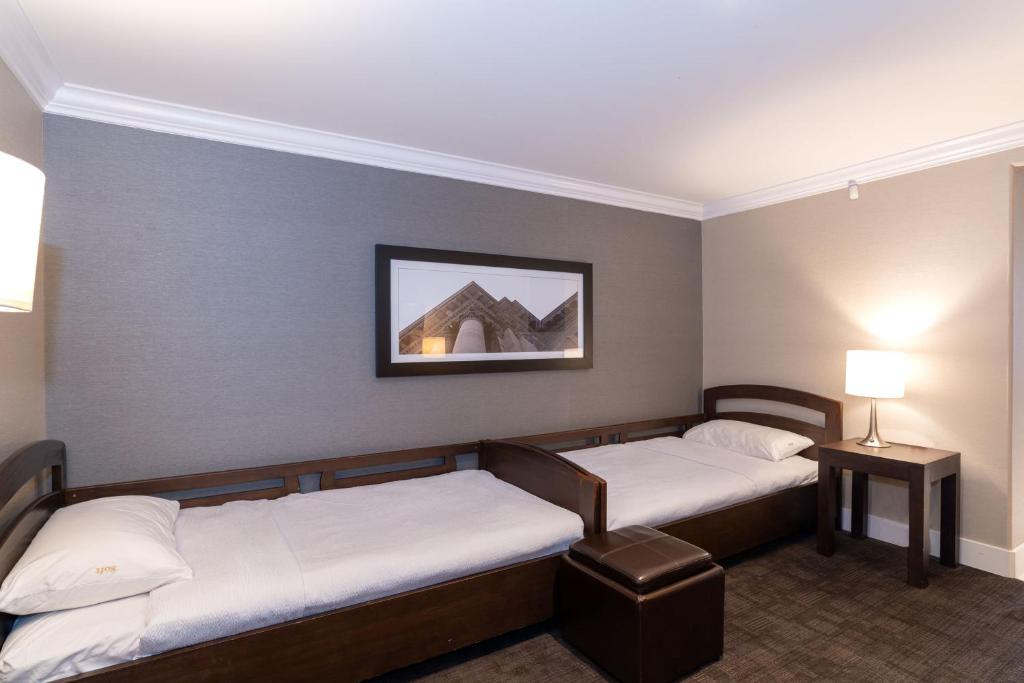 Postel nebo postele na pokoji v ubytování Sandman Signature Prince George Hotel