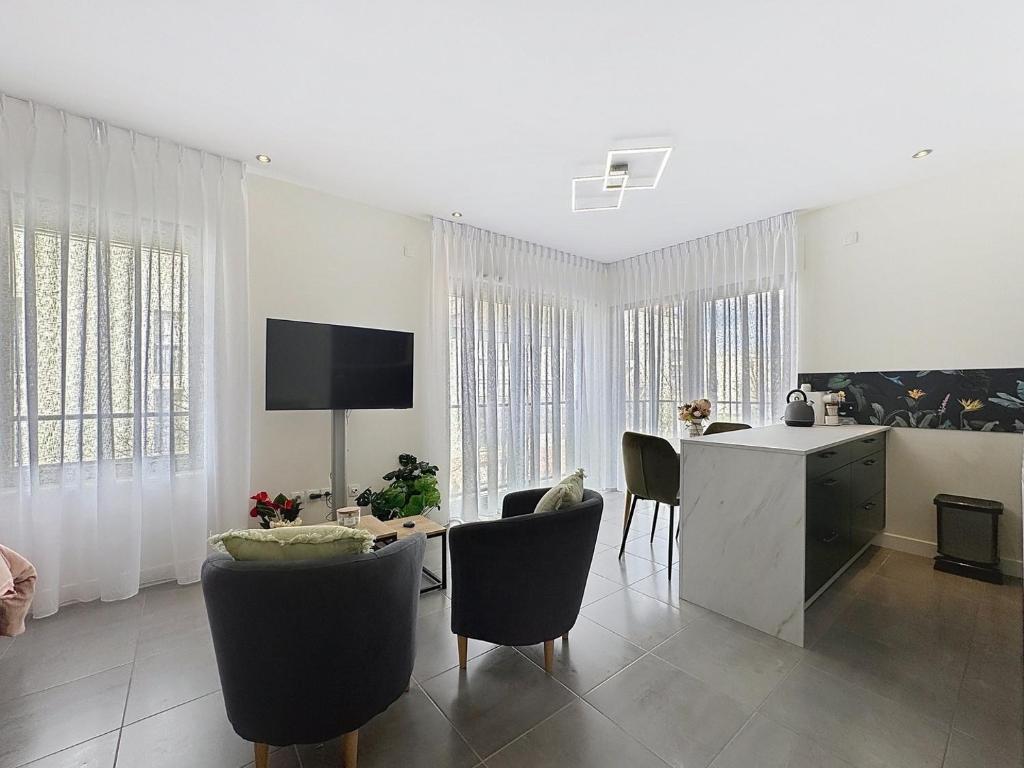 - un salon avec une cuisine et une table avec des chaises dans l'établissement Studio moderne Thouaré sur Loire, à Thouaré-sur-Loire