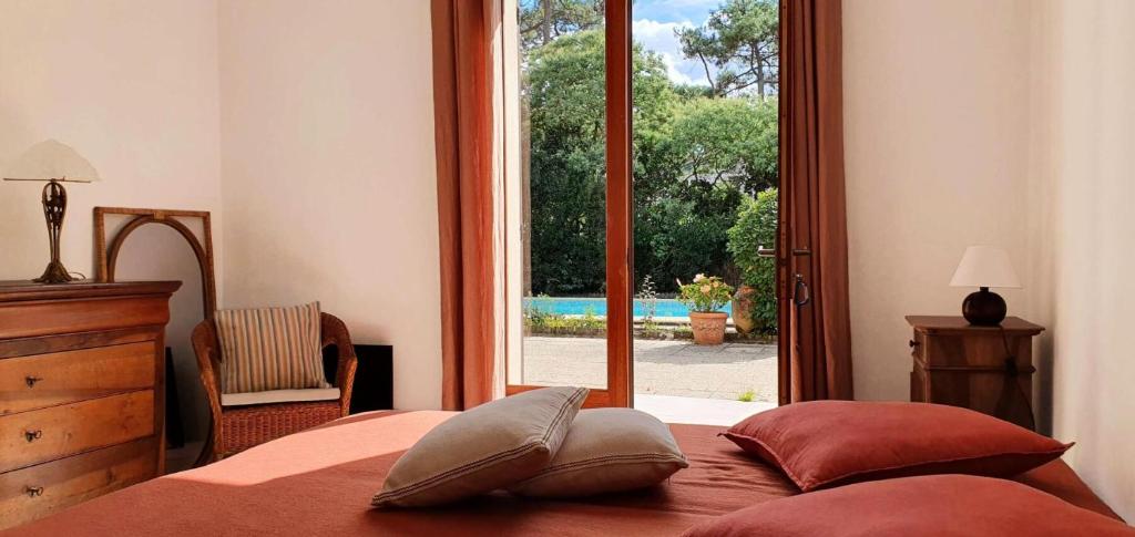 a bedroom with a bed and a large window at Résidence 03272-lacanau Ocean - Villa spacieuse , 3 chambres, 6 personnes, piscine privée à Lacanau océan MAE-0991 in Lacanau