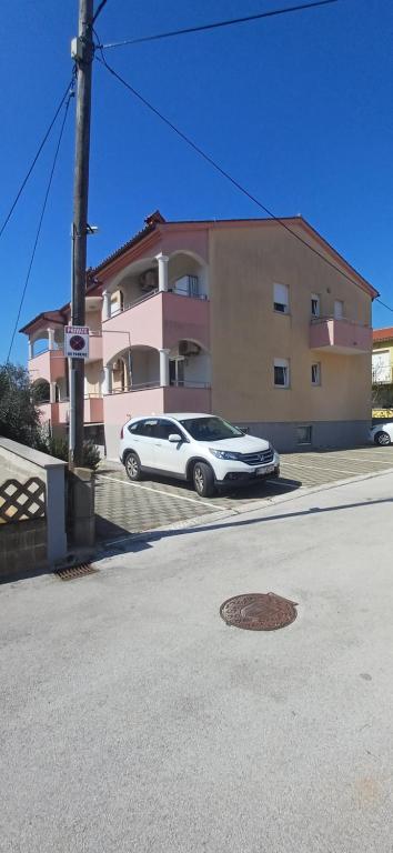 a white car parked in front of a building at Fazana SS in Fažana