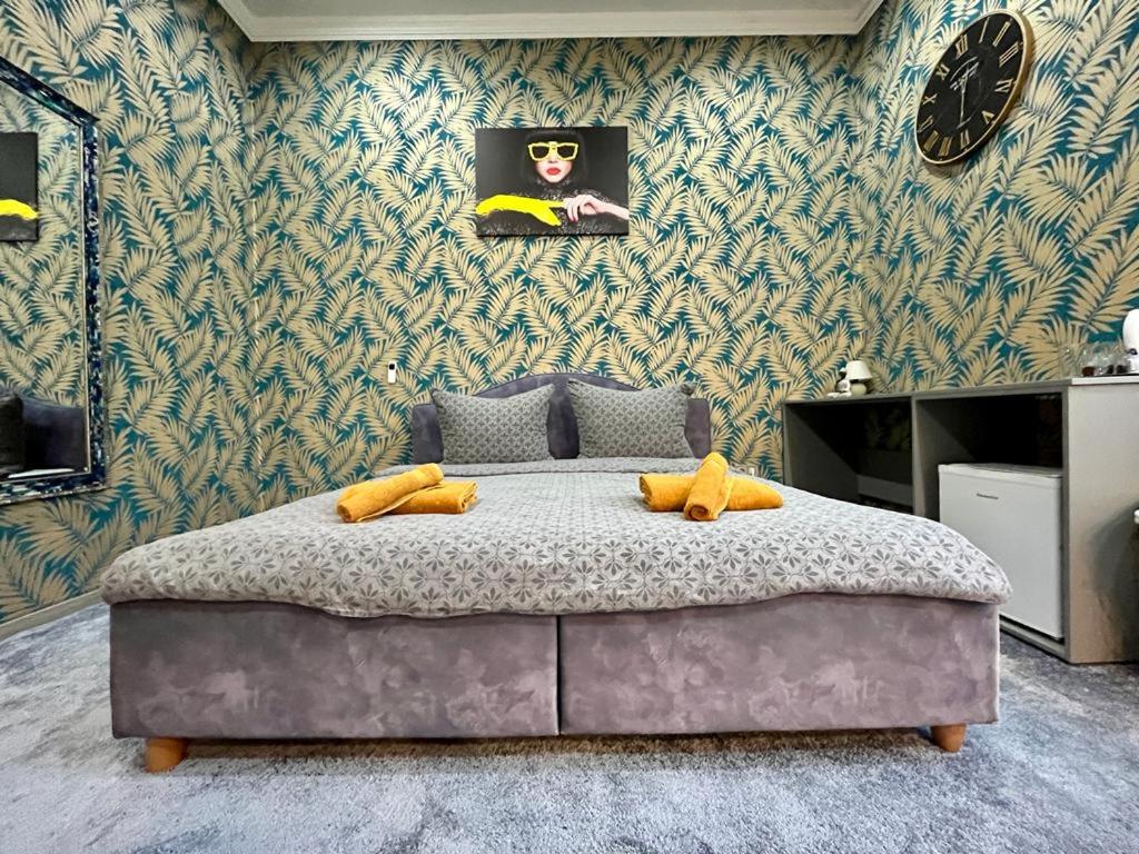 a bedroom with a large bed in a room with wallpaper at JohnGold Gold Room in Debrecen