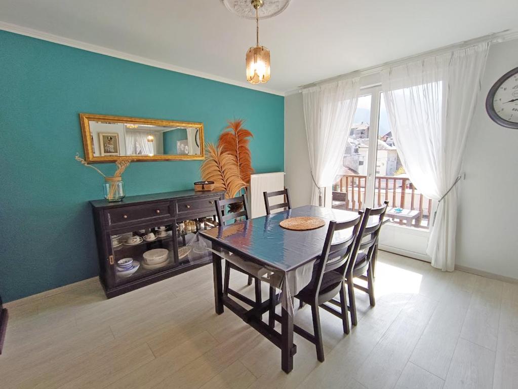 une salle à manger avec une table, des chaises et une horloge dans l'établissement Chez Céleste, Luchon centre, T2 bis, 4 personnes, à Luchon