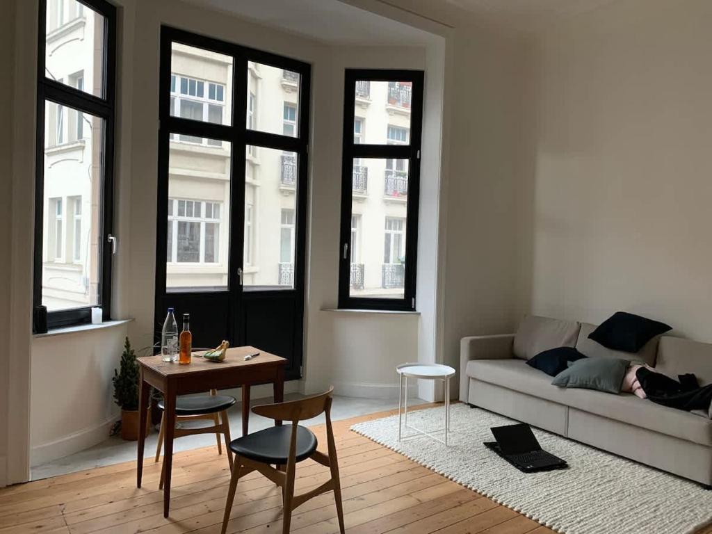 a living room with a couch and a table at Charming studio in the heart of Saint-Gilles in Brussels