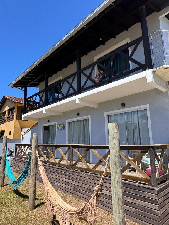 a house with a hammock in front of it at Pousada Tudix in Praia do Rosa