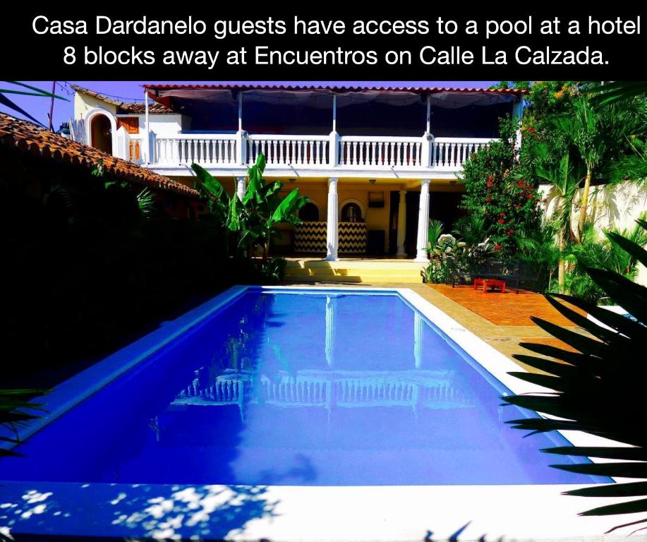 a blue swimming pool in front of a house at Casa Dardanelo in Granada