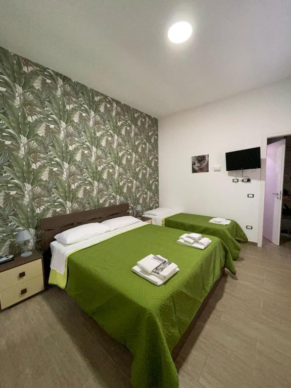 a bedroom with two beds and a green blanket at Casa Letizia a 2 passi dal centro in Marsala