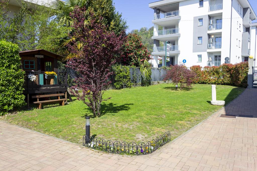 a park with a bench and a tree and a building at Il Gatto Stanco B&B in Arona