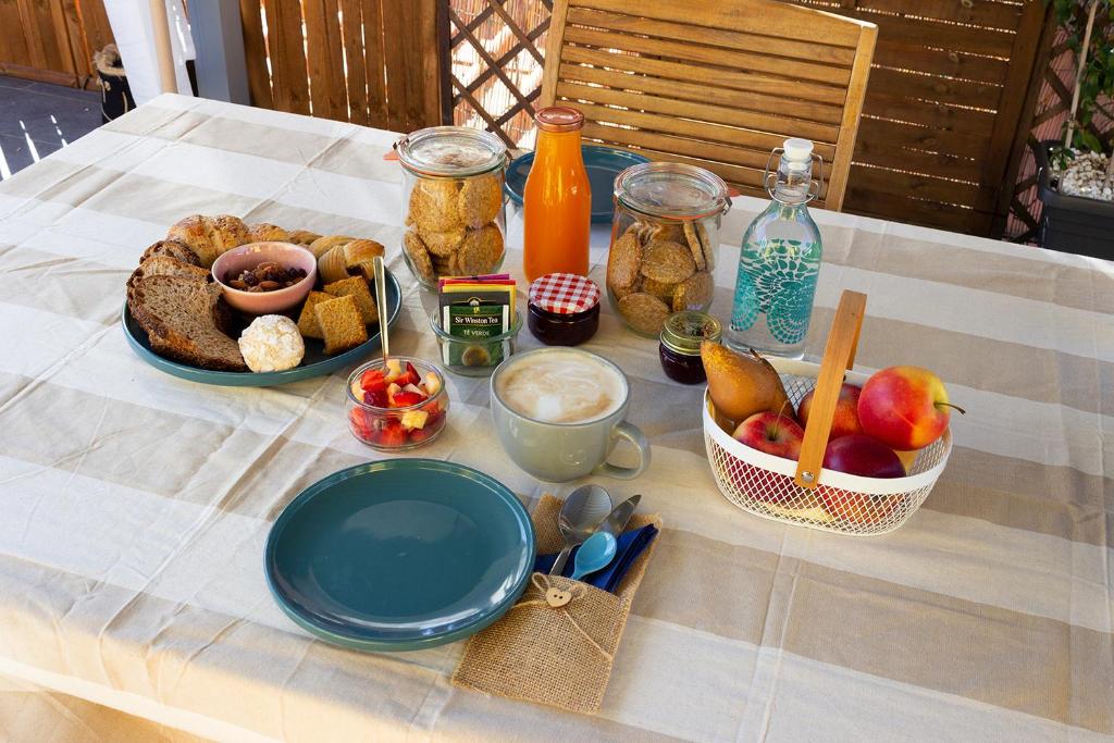 a table with a plate of food and a bowl of fruit at Il Gatto Stanco B&B in Arona