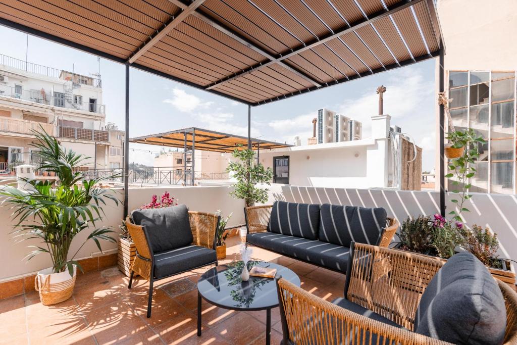 a patio with a couch and chairs on a balcony at Acropolis Rooftop Monastiraki Centrral Gem in Athens