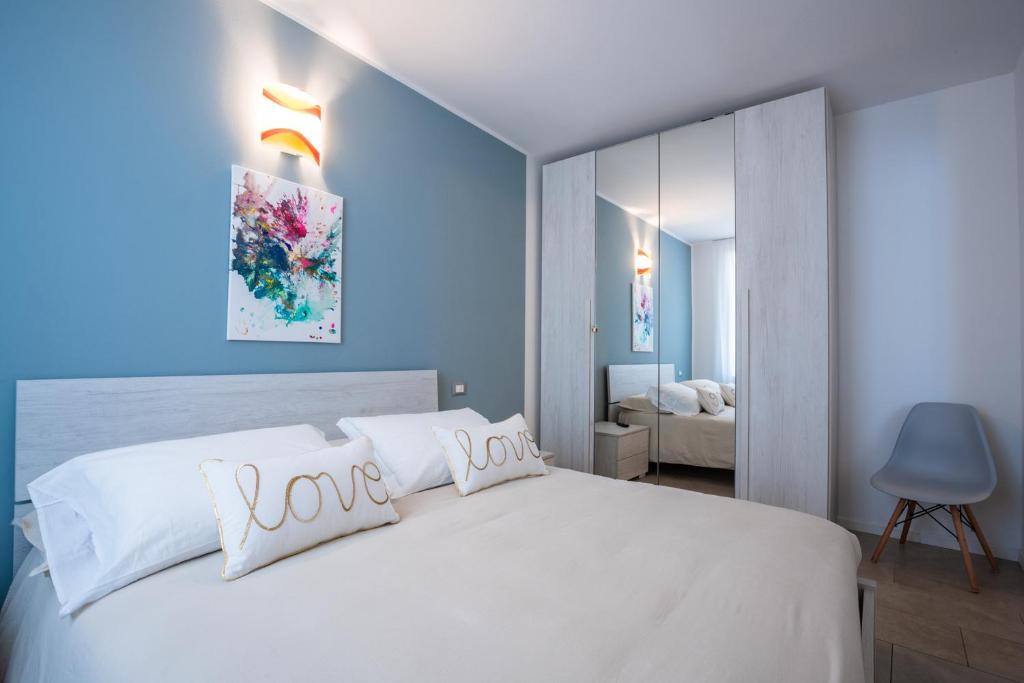 a bedroom with a white bed with love pillows at ES Apartments in Nago-Torbole