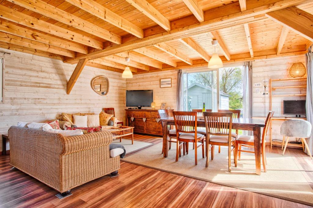 un salon avec une table, des chaises et une télévision dans l'établissement Gîte 