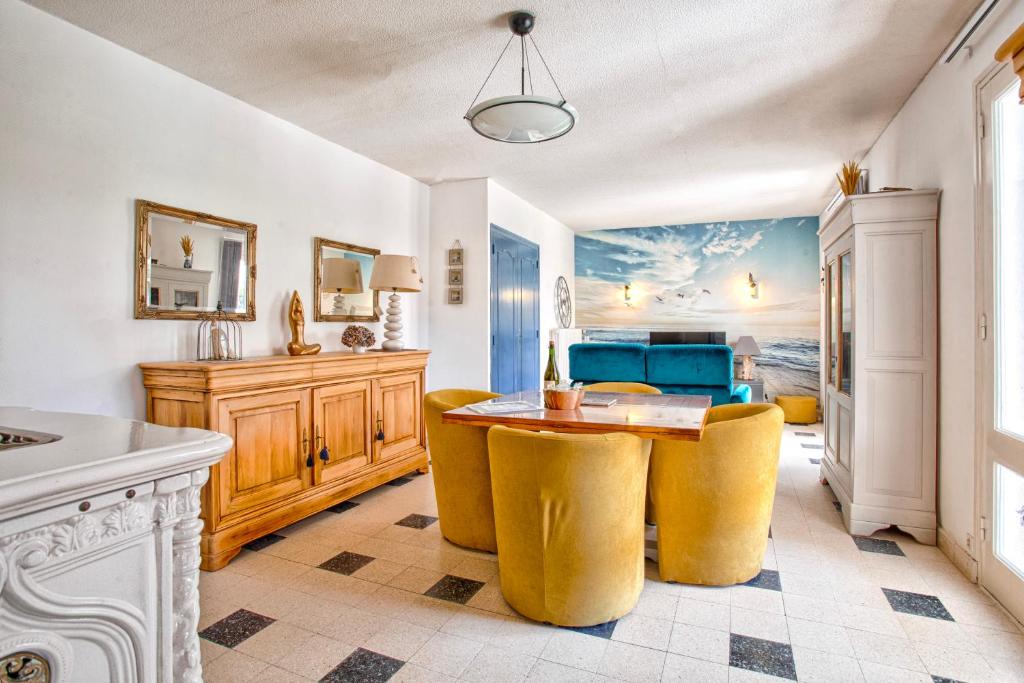 une cuisine avec une table et des chaises jaunes dans l'établissement Gîte L'Escapade - face au golf et à 3 min de la plage de Barneville, à Barneville-Plage