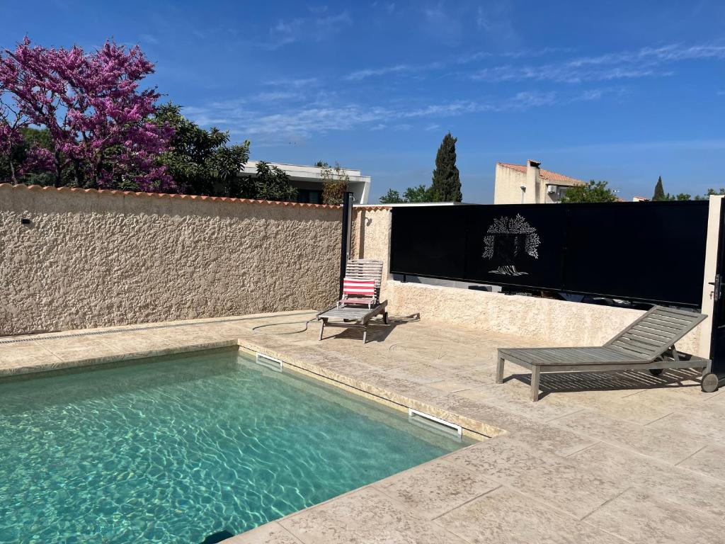 - une piscine avec une chaise à côté d'une clôture dans l'établissement Haut de villa avec piscine privée et extérieur, à Lançon-Provence