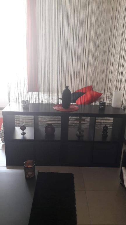 - un salon avec une table et un oreiller rouge dans l'établissement F1 Cozy & Stylish in Hyper-Centre, à Nice