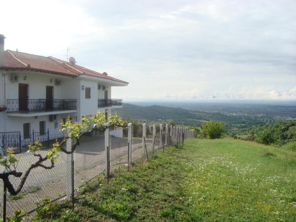 una casa en una colina con una valla en Guesthouse Arsenis, en Kalambaka