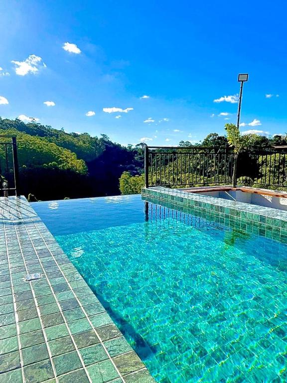 a swimming pool with a clear blue water at Chalé Cantinho da Paz in Santa Teresa