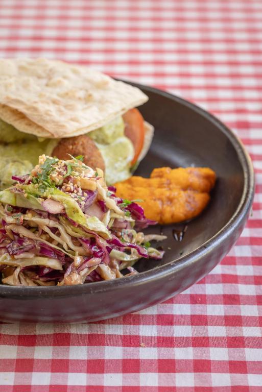 un piatto di cibo con insalata di cavolo e patatine su un tavolo di NOMAD Hostal - Barichara a Barichara
