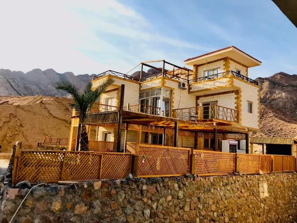 Dahab Hills Villa Resort في دهب: منزل جالس على جدار حجري