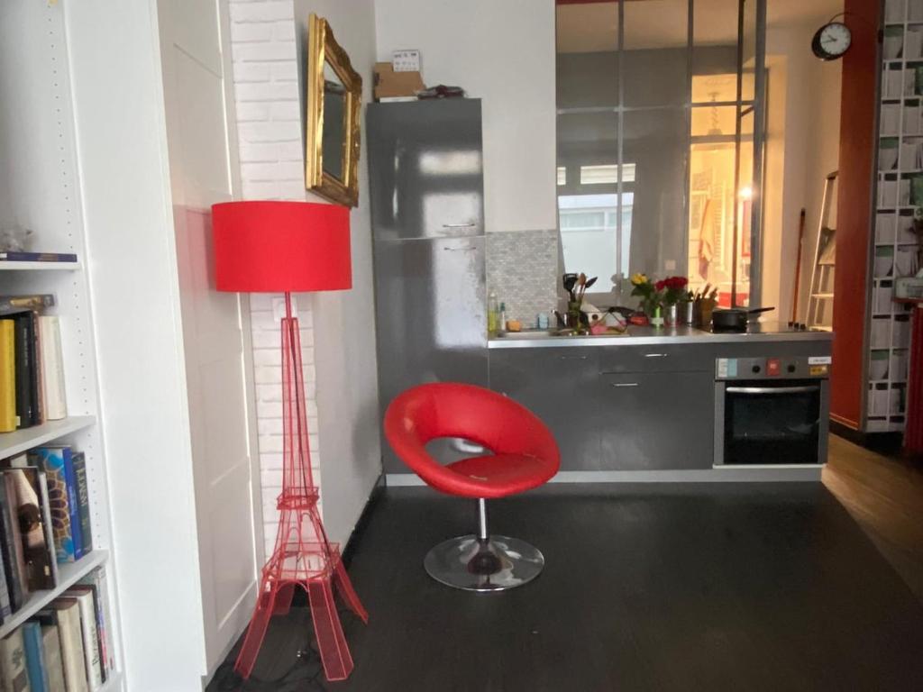 une chaise rouge dans une cuisine avec une lampe rouge dans l'établissement Wonderful and spacious flat in Paris Opera Montmartre, à Paris