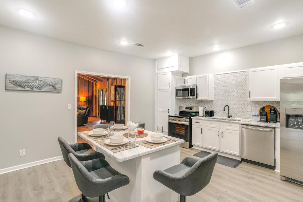 Una cocina con gabinetes blancos y una mesa y sillas. en Smart TV and Spacious Yard Peaceful Pope Retreat, en Pope