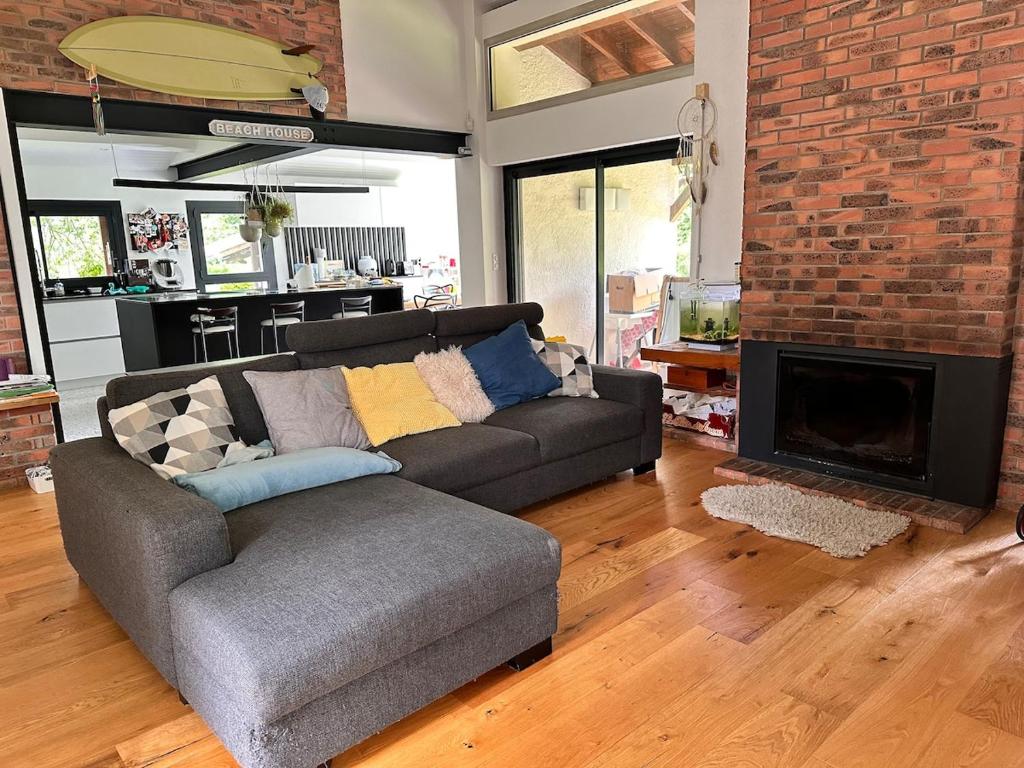 un salon avec un canapé et un mur de briques dans l'établissement Modern Hossegor Oasis, à Soorts-Hossegor