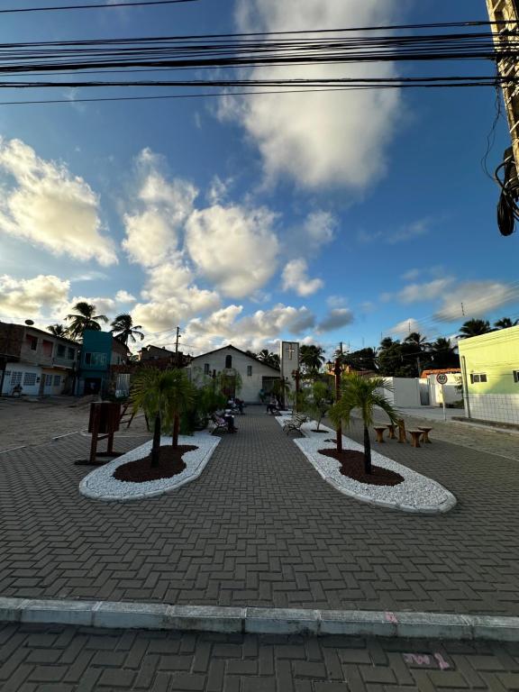 una strada con due alberi su una strada di mattoni di Flat Maré mansa - Praia - bicas - belezas naturais a Japaratinga