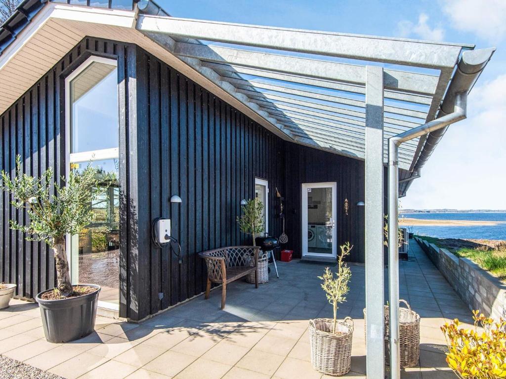 a black house with a patio with trees on it at 5 star holiday home in Løgstrup in Løgstrup