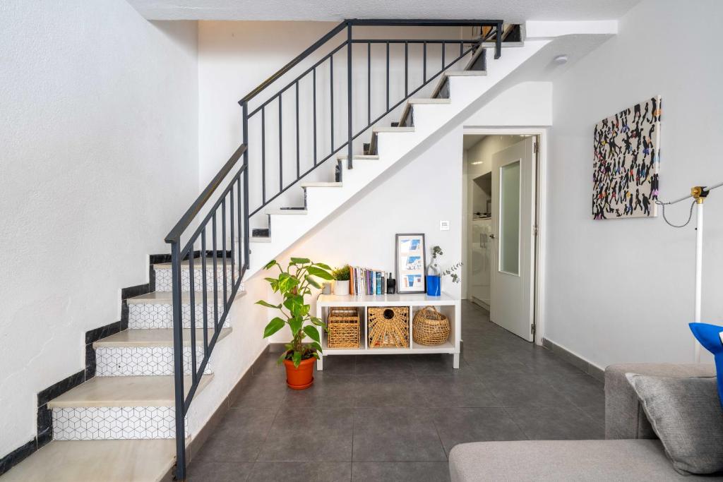 a staircase in a living room with a white wall at Casa Centro Histórico Almería - Jayrán in Almería