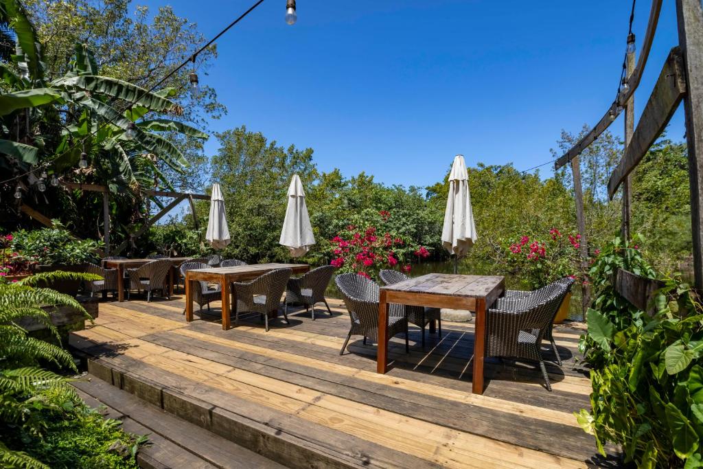 a wooden deck with tables and umbrellas at Pro Cab Paradise Condos Cabarete in Cabarete