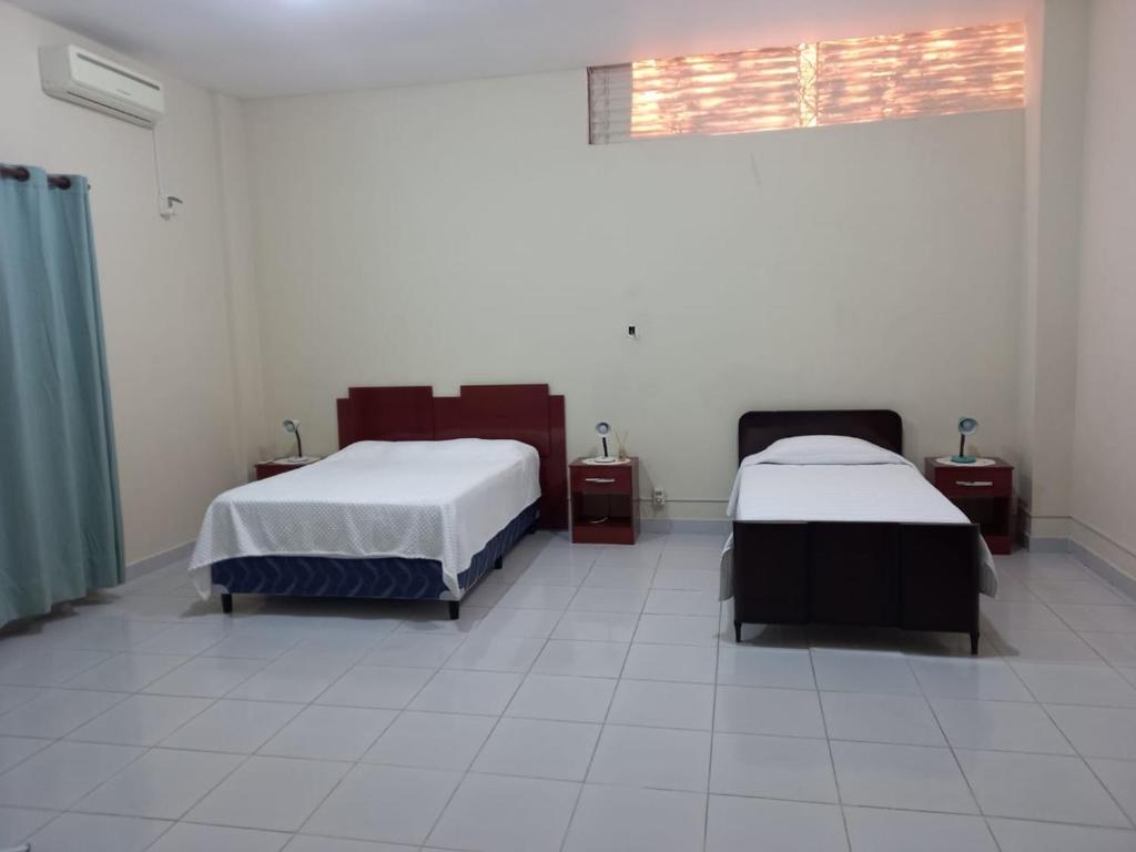 a room with two beds and a window at Casa Centrica in Yacuiba