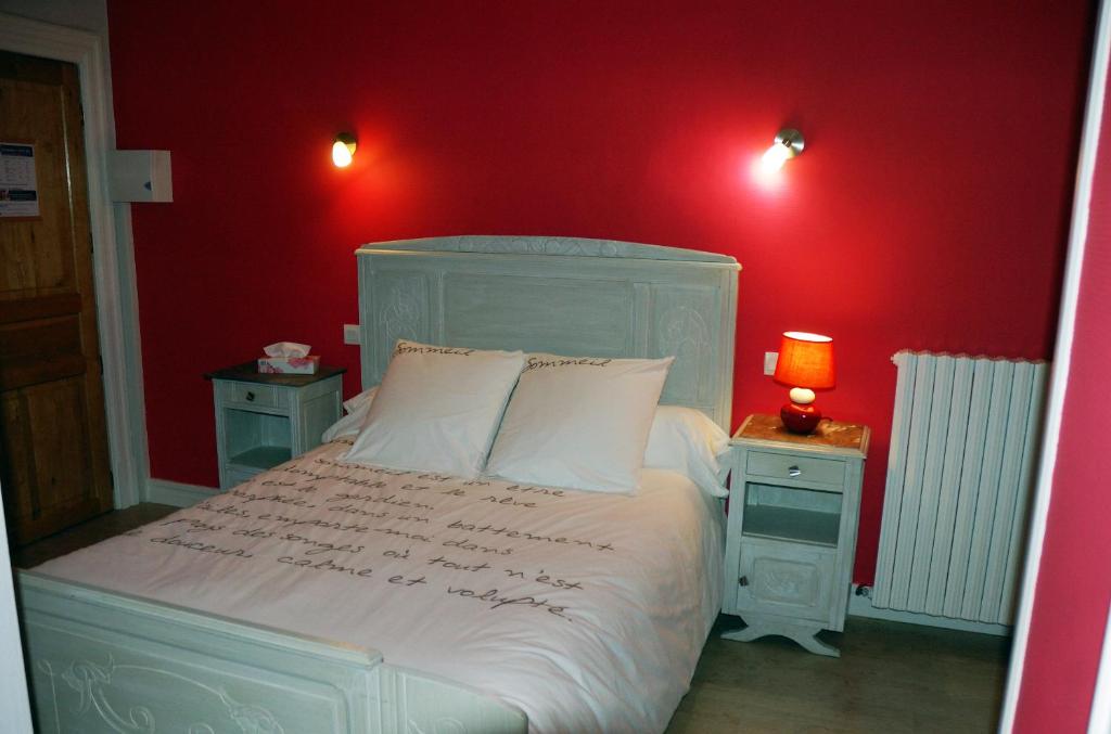 een slaapkamer met een wit bed en rode muren bij L'Horizon des Landes in Doazit