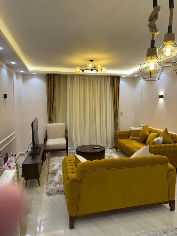 a living room with a yellow couch and a table at Amazing 3BHK Fully Furnished apt in Madinty New Cairo in Madinaty