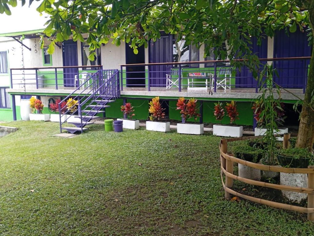 a building with a staircase and flowers in a yard at Finca Turística en Quindío cerca a Panaca in Quimbaya