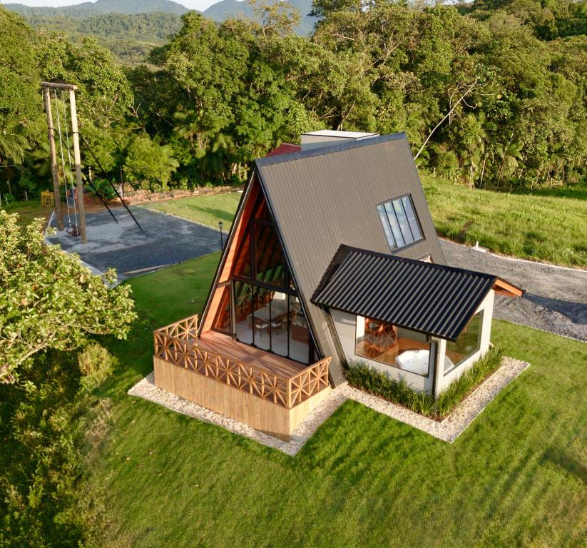 een hond die in een hondenhok op het gras zit bij Kleines Paradies Chalés in Massaranduba