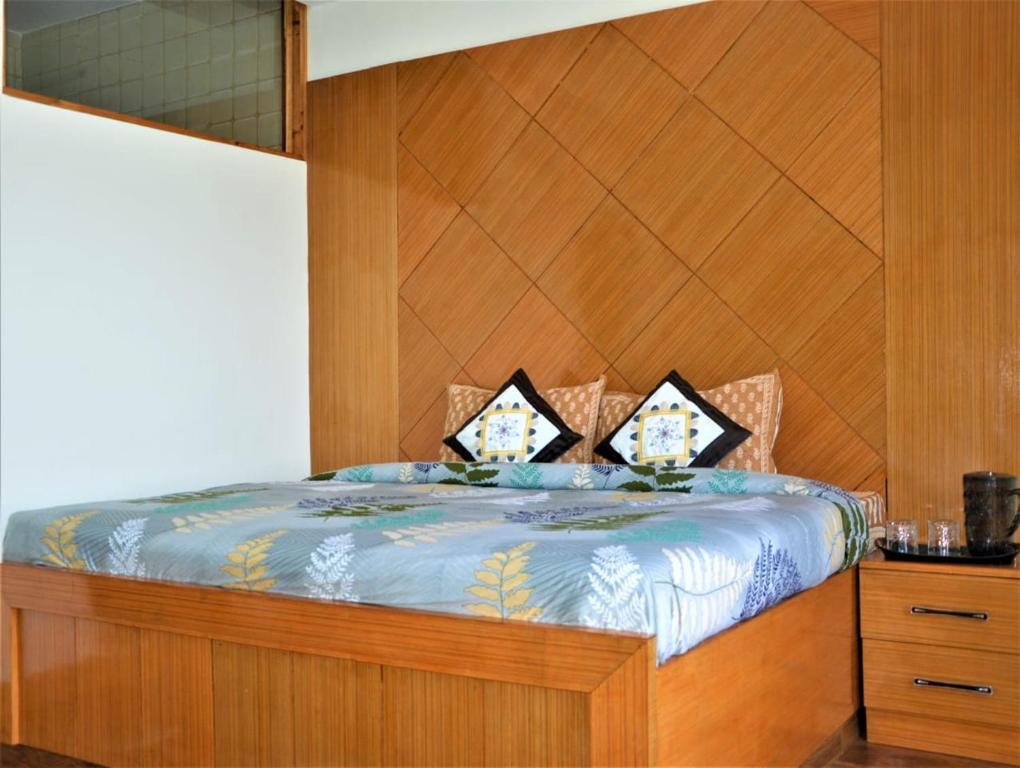 ein Schlafzimmer mit einem Bett mit einem hölzernen Kopfteil in der Unterkunft Ridhi Sidhi Cottage Homestay in Shimla