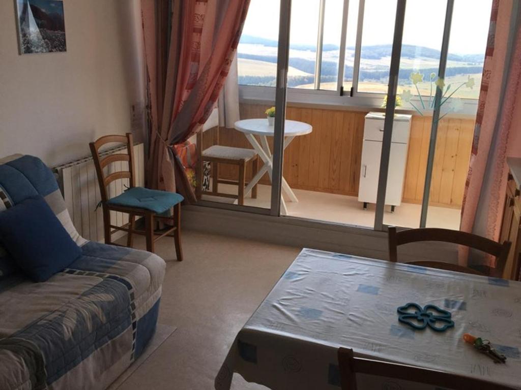 un salon avec un canapé et une table dans l'établissement Studio avec loggia à Super Besse, proche des pistes - FR-1-814-112, à Besse-et-Saint-Anastaise