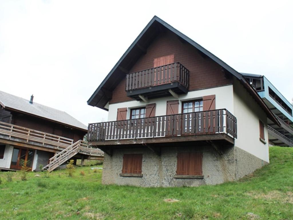 a house with balconies on top of a hill at Chalet Calme sur les Hauteurs - 8 Pers, Proche Pistes - FR-1-814-103 in Besse-et-Saint-Anastaise